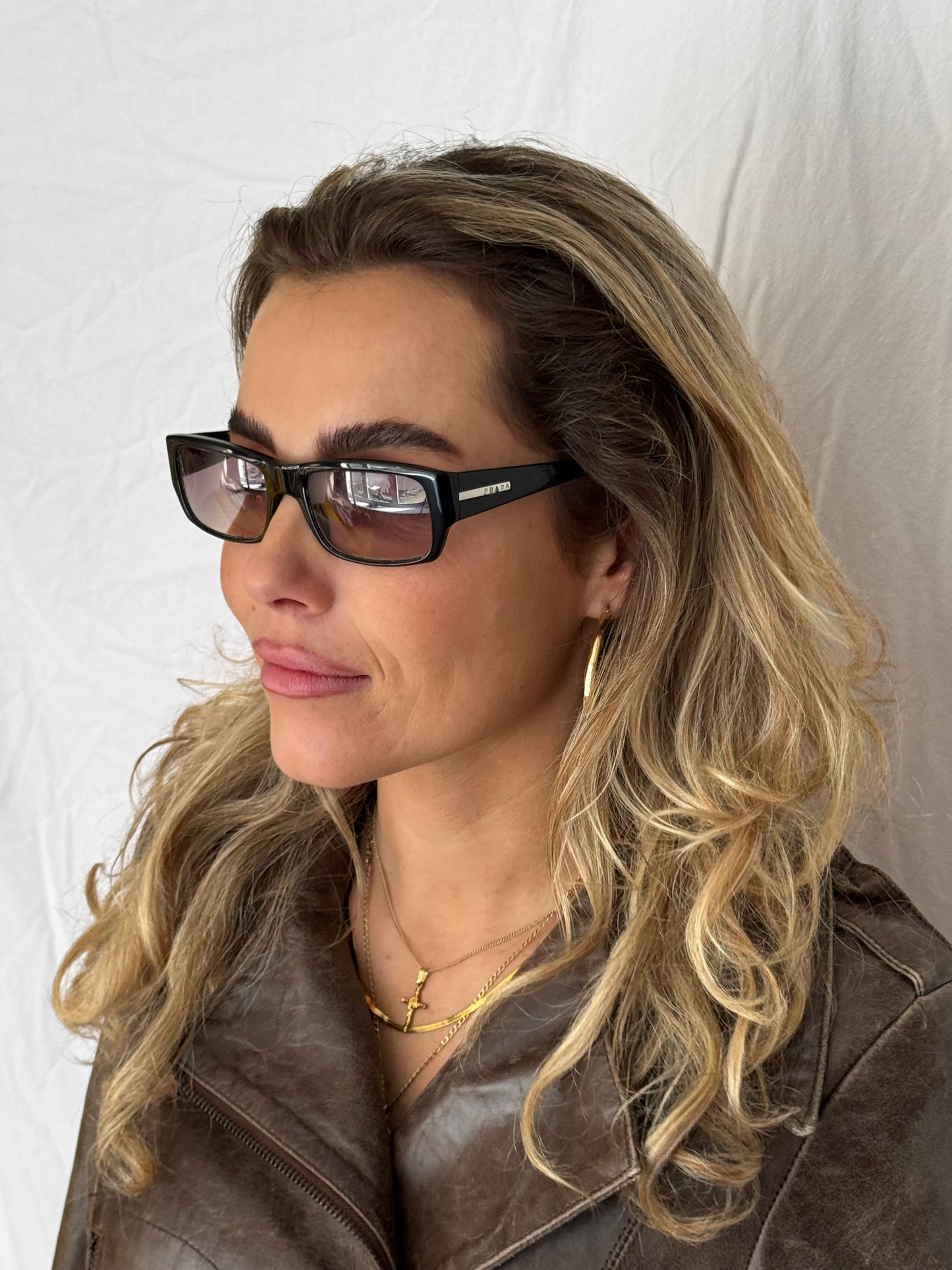 PRADA SUNGLASSES CLOSE UP ON MODEL VINTAGE with brown leather vintage jacket golden jewelry