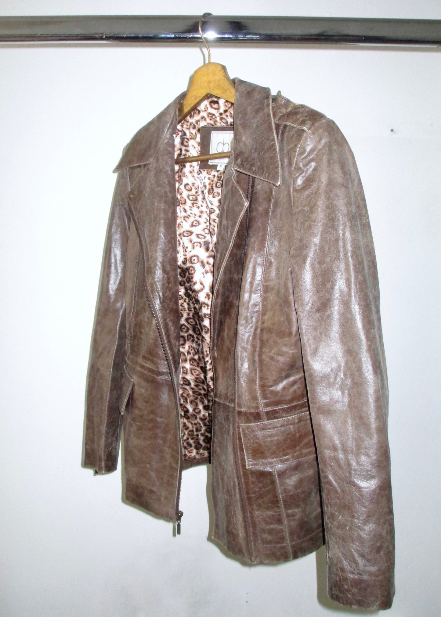 brown leather vintage jacket on hanger with leopard print lining